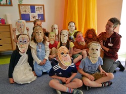 Die Kinder haben Orang-Utan-Masken gestaltet und tragen diese nun stolz.