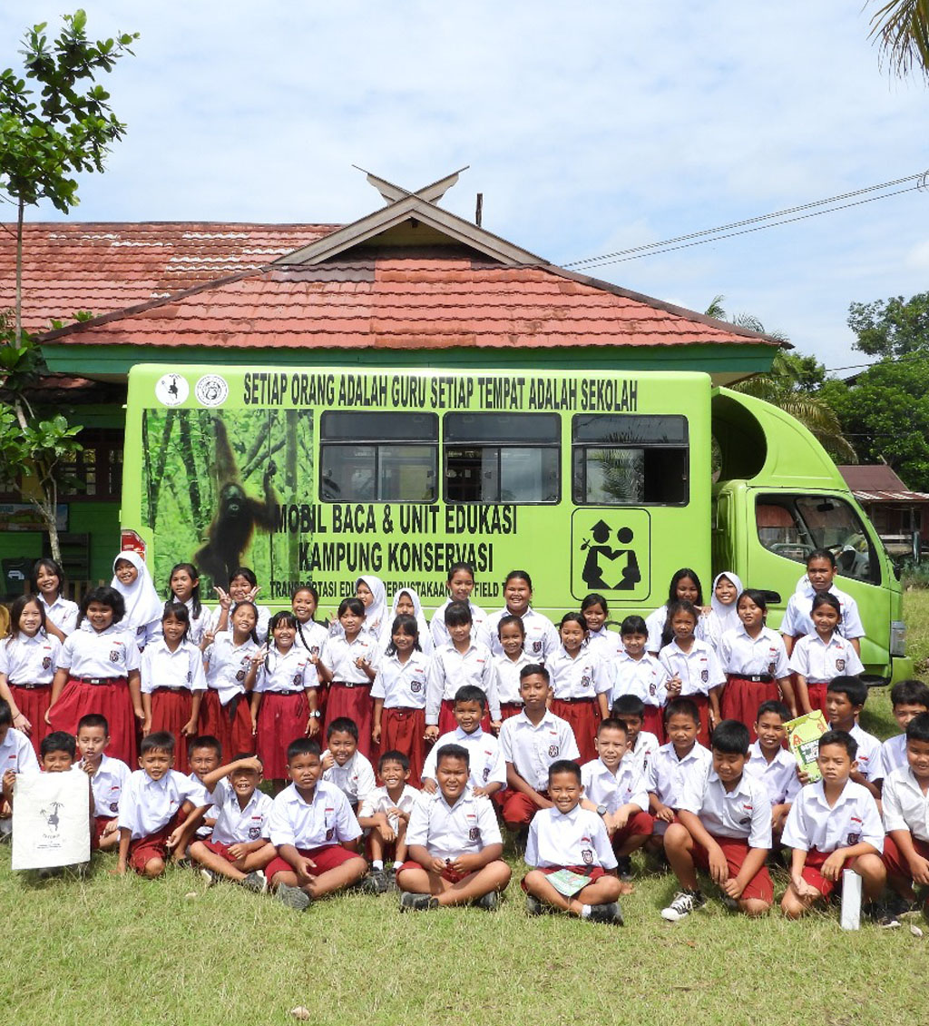 Gruppenfoto einer indonesischen Schulklasse vor dem Umweltbibliotheksbus.